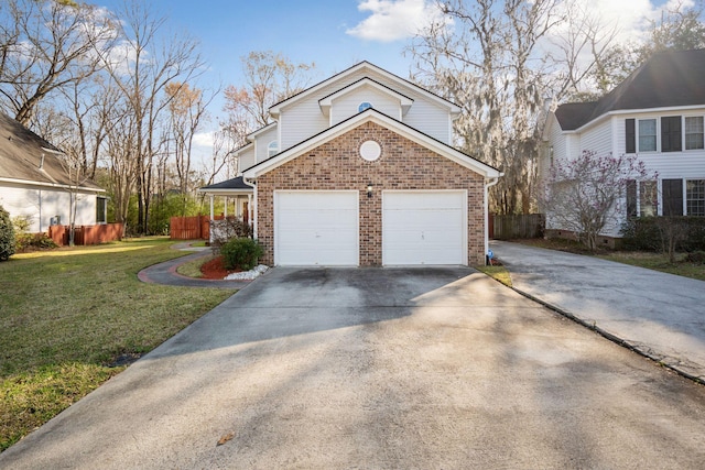 view of front of house featuring brick siding, driveway, a front lawn, and fence