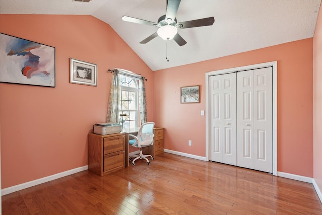 office featuring light wood finished floors, visible vents, baseboards, ceiling fan, and vaulted ceiling