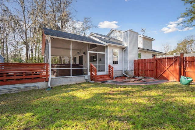 rear view of house featuring a sunroom, a gate, a yard, and fence