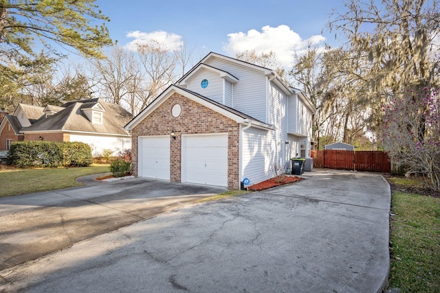 view of side of property with fence, concrete driveway, and brick siding