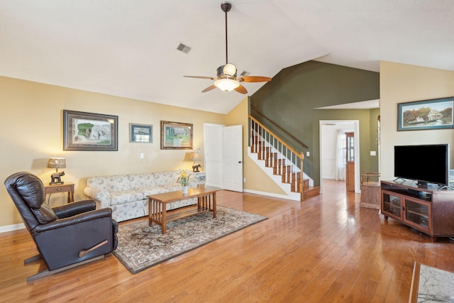 living room with lofted ceiling, stairway, hardwood / wood-style floors, a ceiling fan, and baseboards