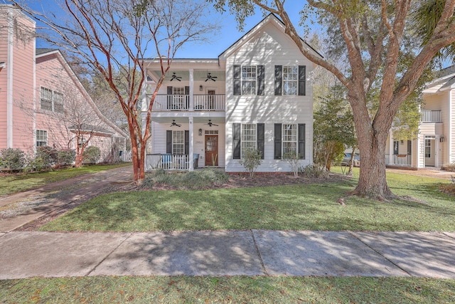 view of front of home featuring a balcony, covered porch, ceiling fan, and a front lawn