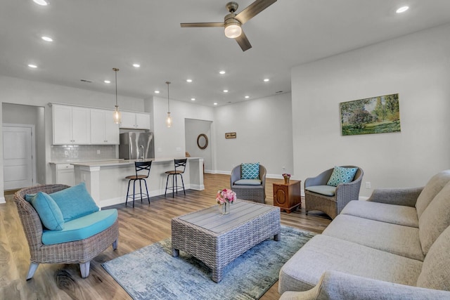 living room featuring light hardwood / wood-style floors and ceiling fan