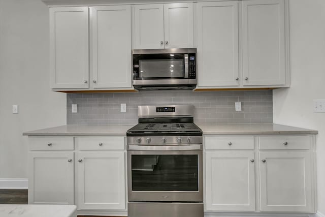 kitchen featuring white cabinetry, decorative backsplash, and stainless steel appliances