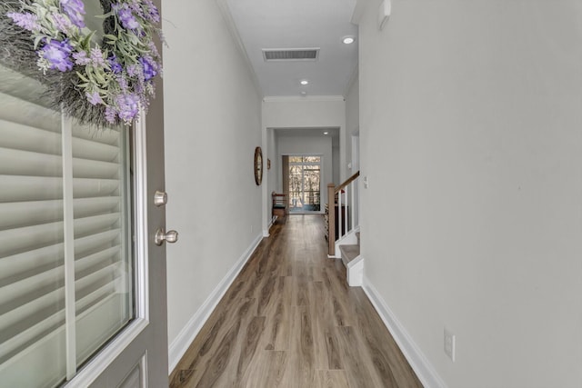 corridor with ornamental molding and wood-type flooring