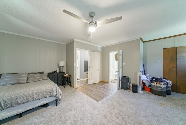 bedroom featuring ceiling fan, ensuite bathroom, ornamental molding, and carpet floors