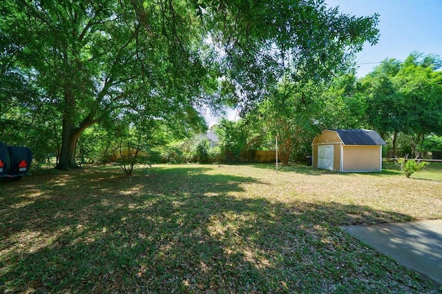 view of yard with a garage, an outbuilding, a storage shed, and a fenced backyard