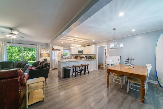dining space featuring crown molding, wood finished floors, baseboards, and recessed lighting