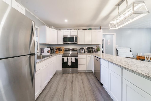 kitchen with light wood-style floors, stainless steel appliances, and white cabinets