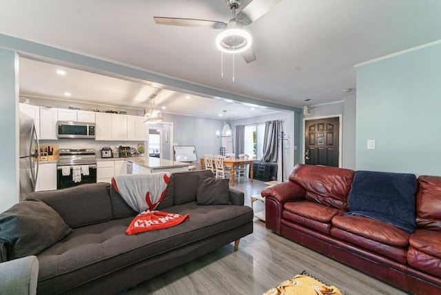 living room with a ceiling fan, recessed lighting, light wood finished floors, and crown molding