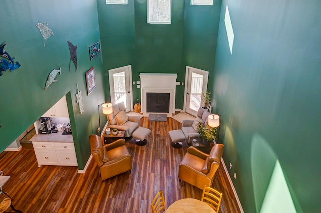 212 Chester Ln, Cottageville, SC 29435 - living room with baseboards, dark wood-style flooring, a fireplace with raised hearth, and a towering ceiling