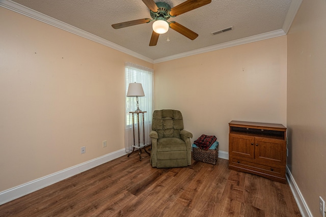 sitting room featuring crown molding, a textured ceiling, dark hardwood / wood-style flooring, and ceiling fan