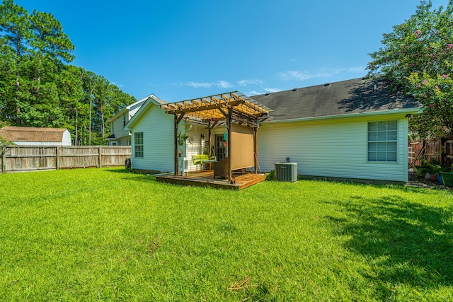 rear view of property featuring a pergola, central air condition unit, and a lawn