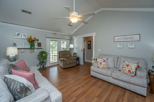 living room featuring hardwood / wood-style floors, vaulted ceiling, a textured ceiling, ceiling fan, and ornamental molding