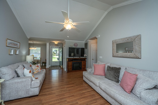 living room featuring hardwood / wood-style floors, decorative columns, crown molding, ceiling fan with notable chandelier, and lofted ceiling