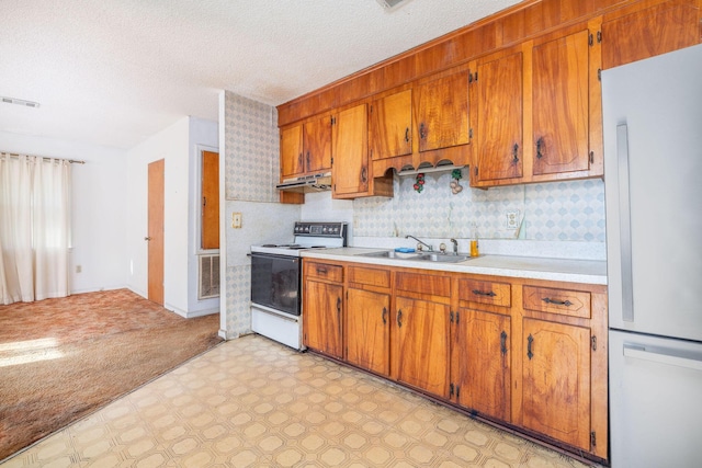 kitchen with sink, stainless steel refrigerator, white electric range oven, tasteful backsplash, and a textured ceiling