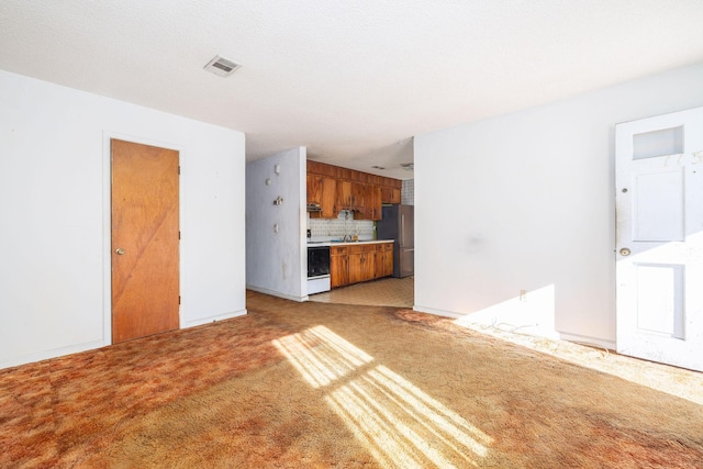 unfurnished living room featuring light carpet