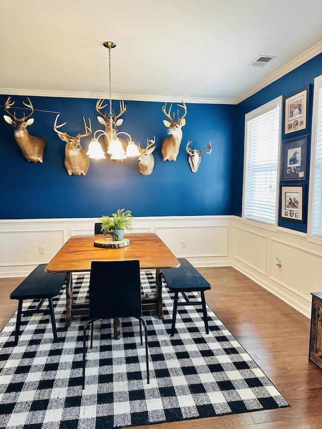 dining room featuring breakfast area, ornamental molding, dark hardwood / wood-style flooring, and a chandelier