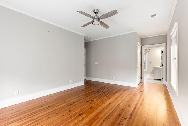 empty room with ceiling fan, light wood-type flooring, baseboards, and crown molding