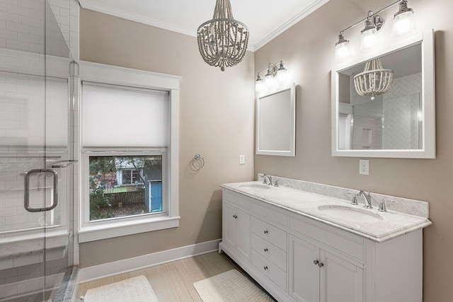 bathroom featuring a chandelier, a shower stall, double vanity, baseboards, and crown molding