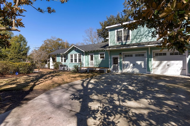 traditional-style house with concrete driveway, a shingled roof, and an attached garage