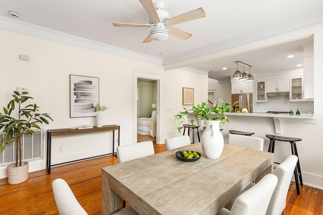 dining space with ceiling fan, wood finished floors, crown molding, baseboards, and recessed lighting