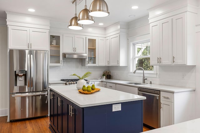 kitchen featuring appliances with stainless steel finishes, a sink, under cabinet range hood, white cabinets, and recessed lighting