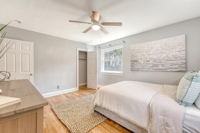 bedroom with a closet, baseboards, ceiling fan, and light wood-type flooring
