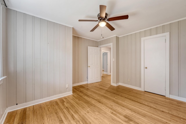 unfurnished bedroom featuring crown molding, baseboards, a ceiling fan, and light wood finished floors