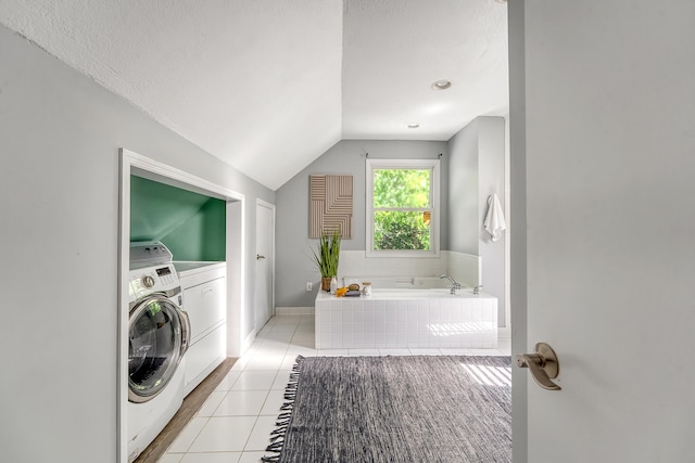 laundry room with laundry area, baseboards, light tile patterned flooring, and washing machine and clothes dryer