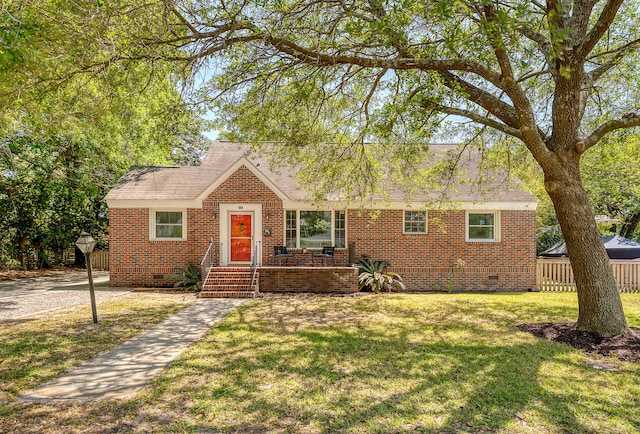 ranch-style home featuring crawl space, roof with shingles, brick siding, fence, and a front lawn