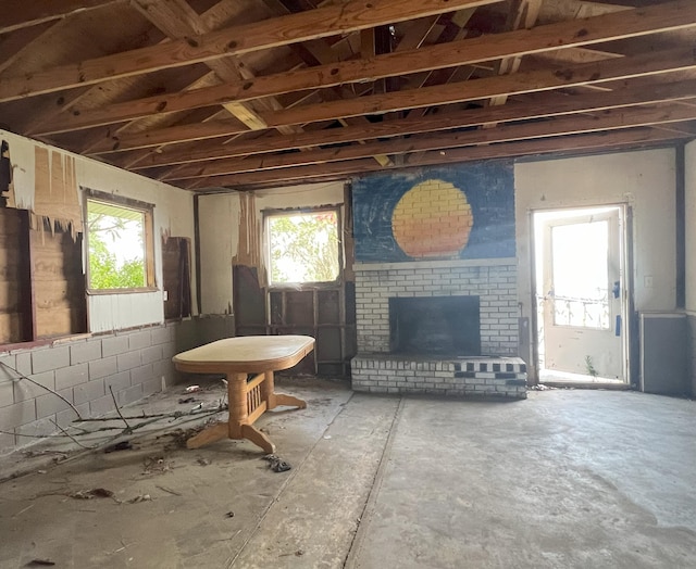 living room featuring concrete floors and a brick fireplace