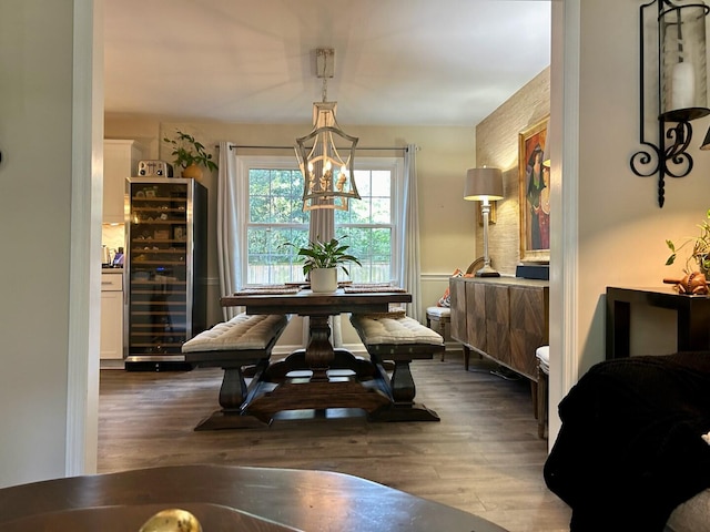 dining area featuring a notable chandelier, hardwood / wood-style flooring, and beverage cooler