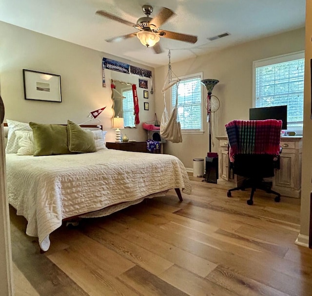 bedroom with light hardwood / wood-style floors, multiple windows, and ceiling fan