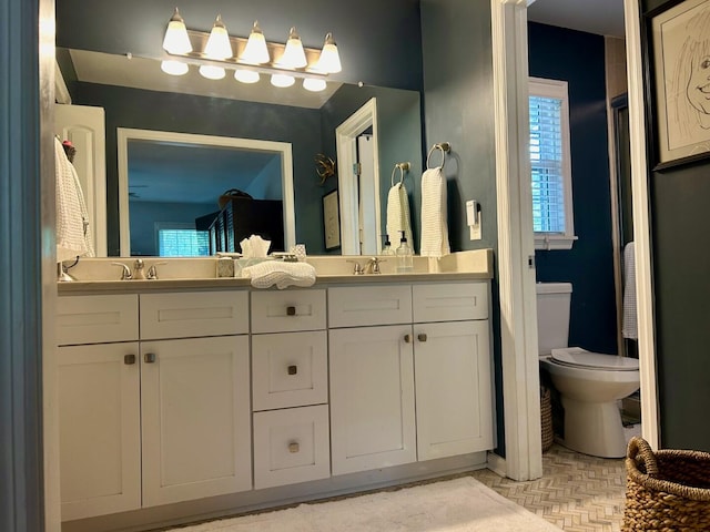 bathroom with vanity, parquet floors, and toilet