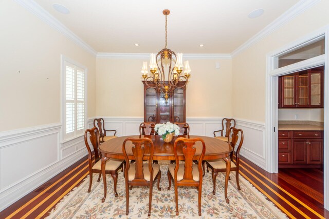 dining room with ornamental molding, dark hardwood / wood-style flooring, and a chandelier