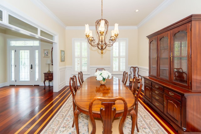 dining room with ornamental molding, dark wood-style flooring, a notable chandelier, and wainscoting