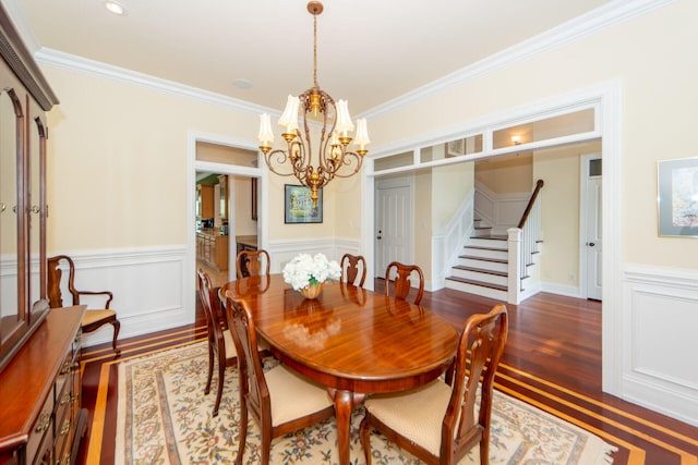 dining space featuring stairway, dark wood-style flooring, crown molding, and a chandelier