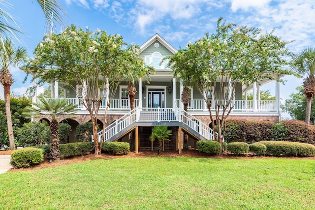 view of front of property featuring covered porch, a front yard, and stairs