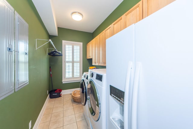 laundry room with baseboards, light tile patterned flooring, cabinet space, and washing machine and clothes dryer