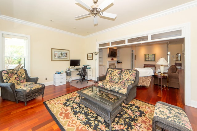 living room with a ceiling fan, baseboards, ornamental molding, and wood finished floors