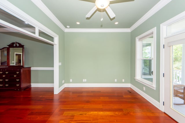 unfurnished room with ornamental molding, baseboards, and wood finished floors