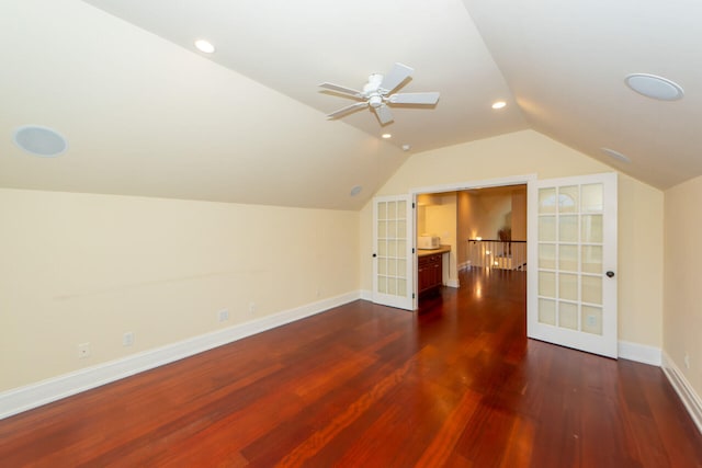 additional living space featuring dark wood-style floors, french doors, vaulted ceiling, and baseboards