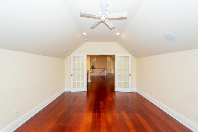 bonus room with lofted ceiling, ceiling fan, dark wood-style flooring, and baseboards