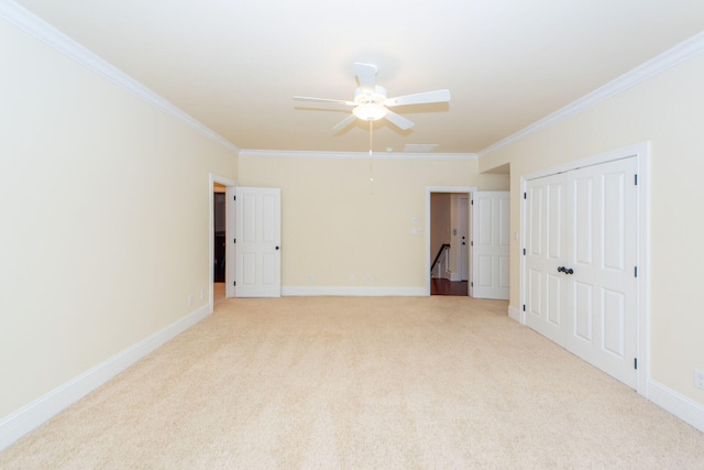 carpeted empty room with ceiling fan and crown molding