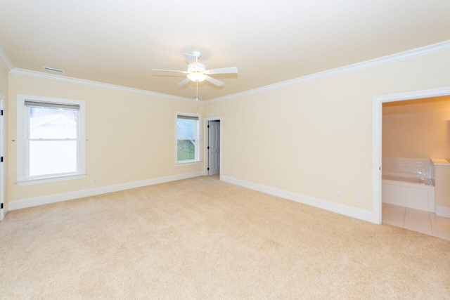 spare room with ornamental molding, a healthy amount of sunlight, and light colored carpet