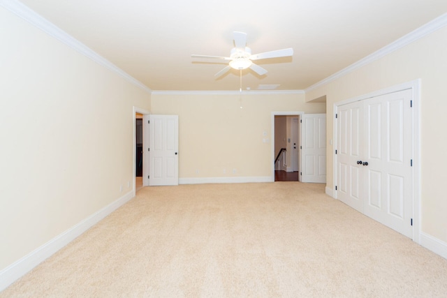 unfurnished room featuring baseboards, light carpet, a ceiling fan, and crown molding