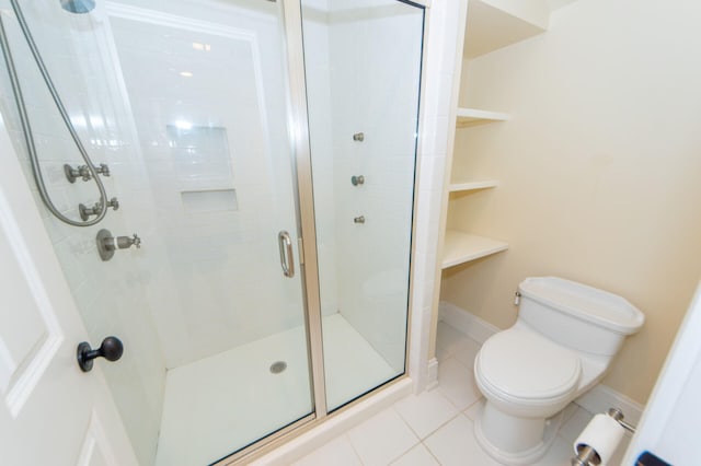 bathroom with baseboards, a shower stall, toilet, and tile patterned floors