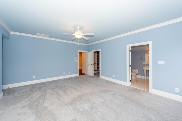 empty room with ornamental molding, light colored carpet, baseboards, and a ceiling fan