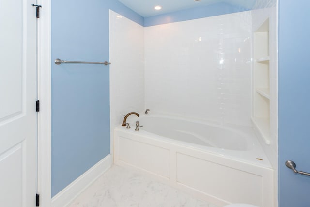 bathroom featuring baseboards and a bath